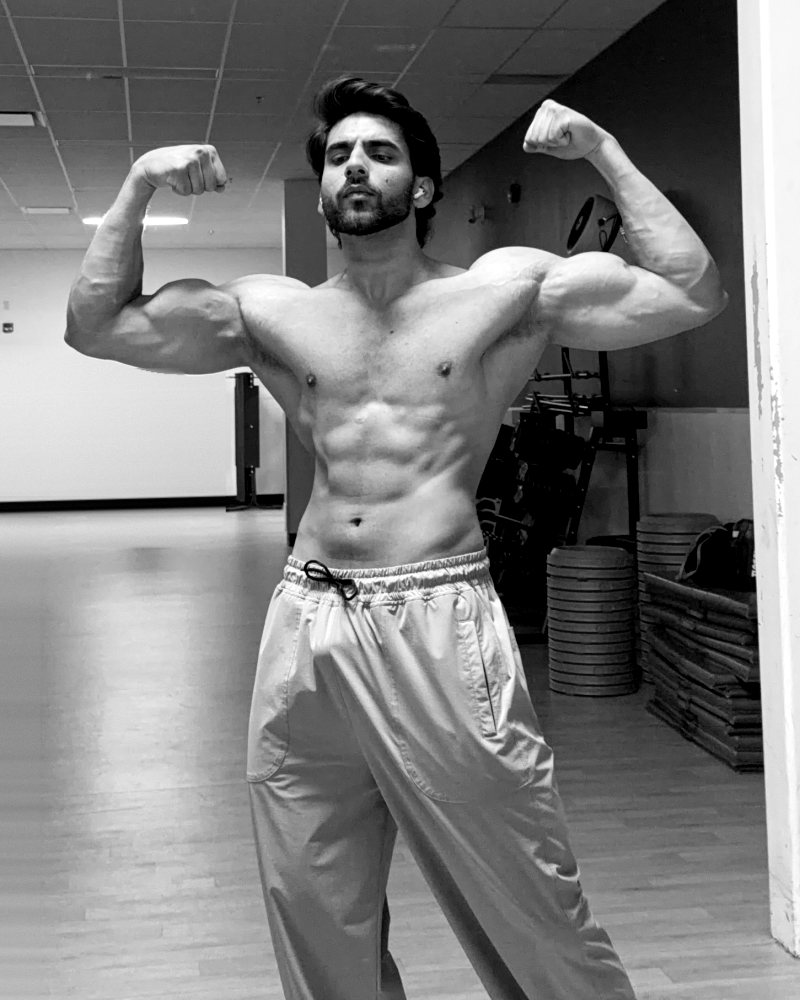 Sapan, coach at 3FIT Coaching, flexing in the gym